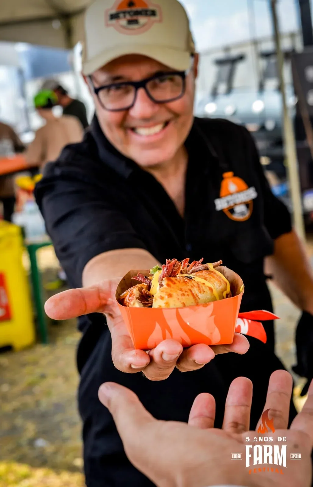 Assador sorridente servindo porção no Farm Festival